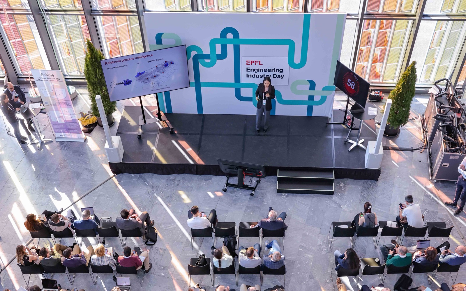Mengjie Zhao pitching KIIO on the Agora stage at EPFL Engineering Industry Day, seen from above with the audience